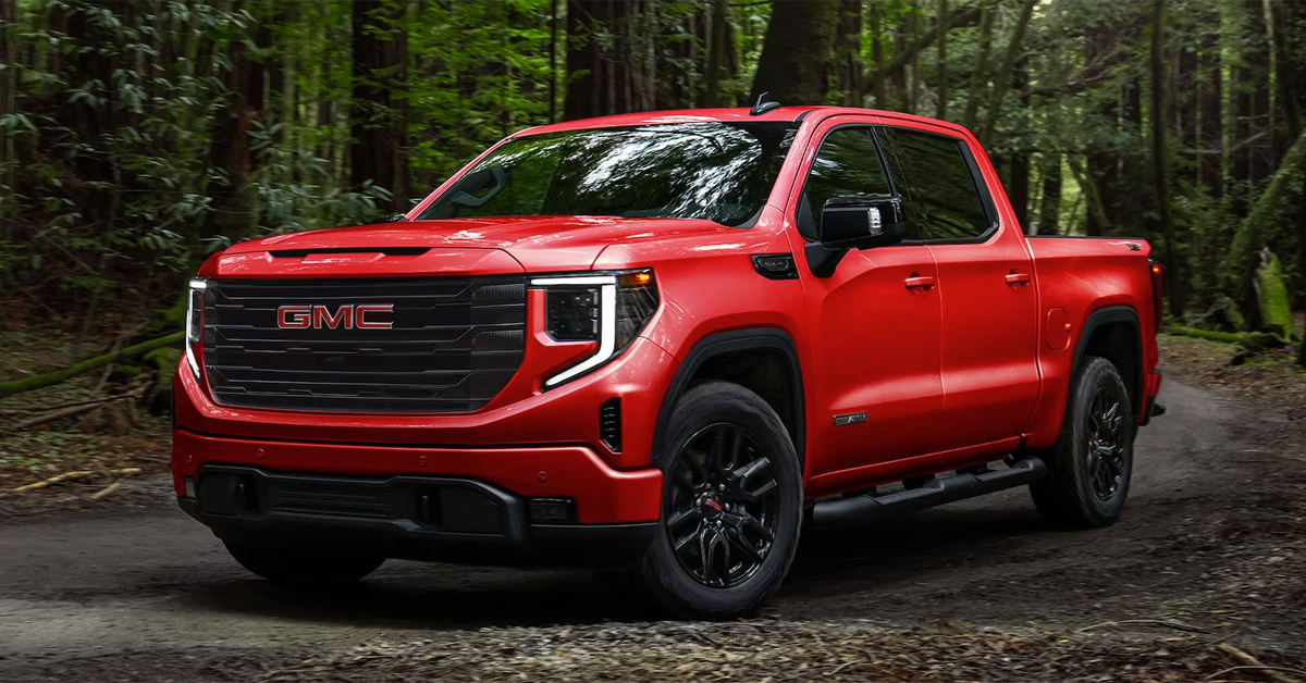 2024 GMC Sierra 1500 in red with black rims parked in the forest