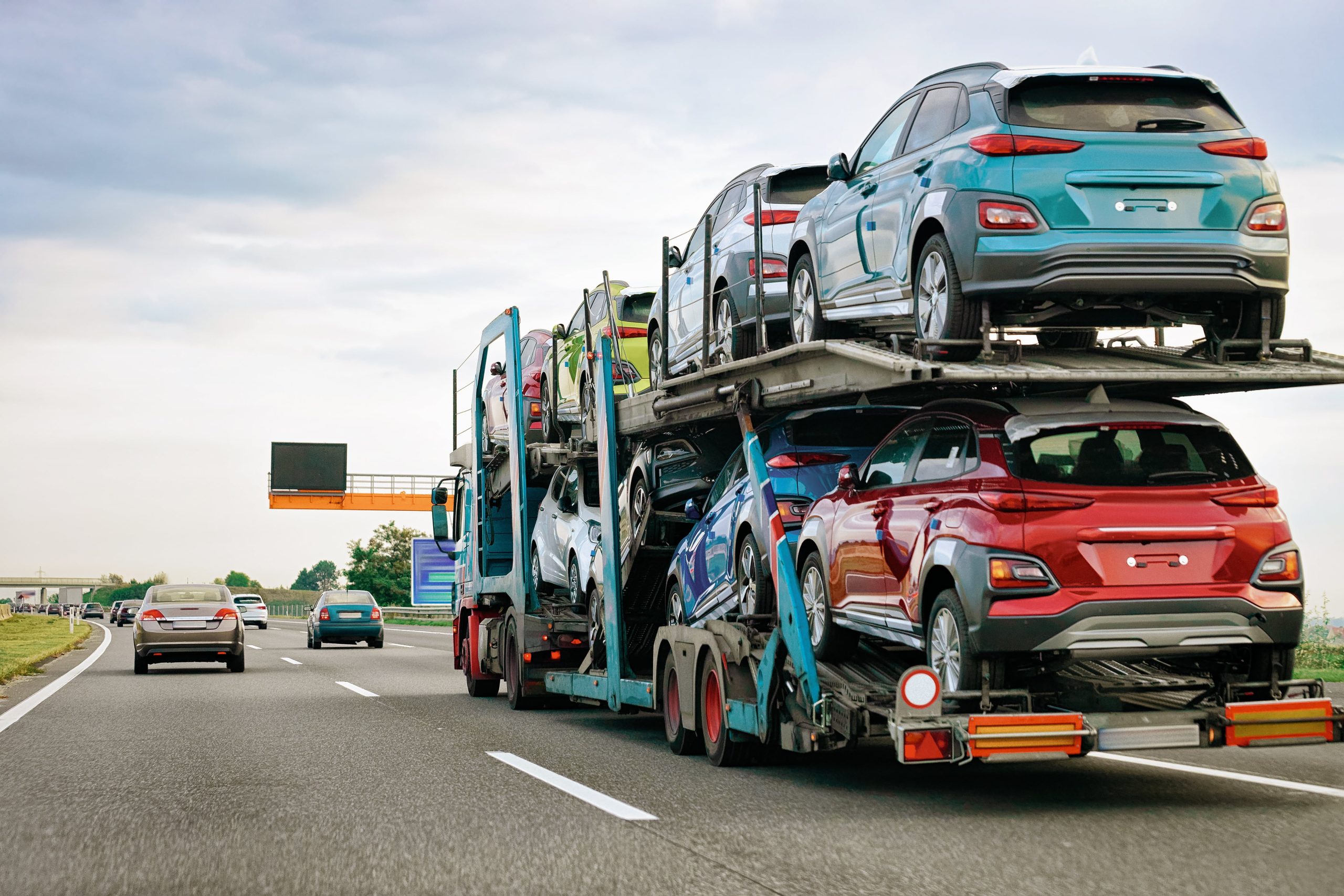 Cars on a transport truck driving down a highway
