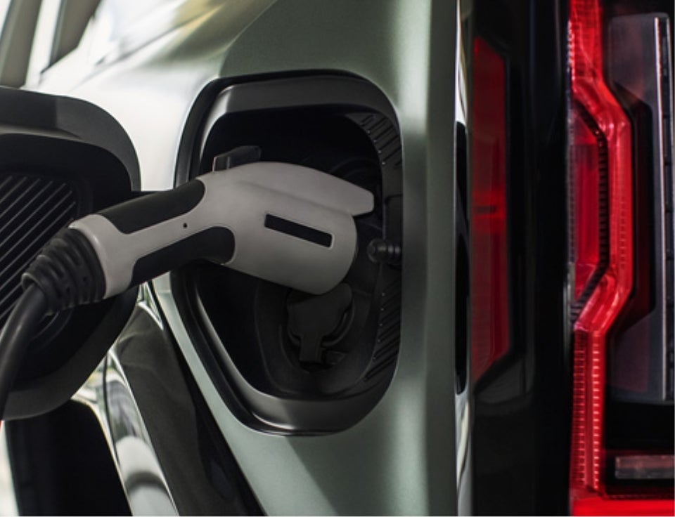 Close up of charging port with charger plugged in on a GMC Hummer EV SUV - Huston GMC in LAKE WALES FL