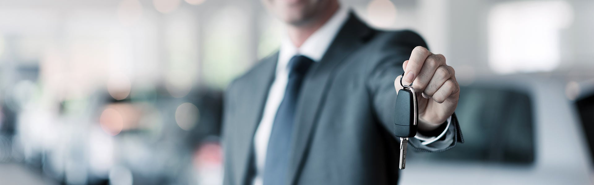 Man in suit holding a car key